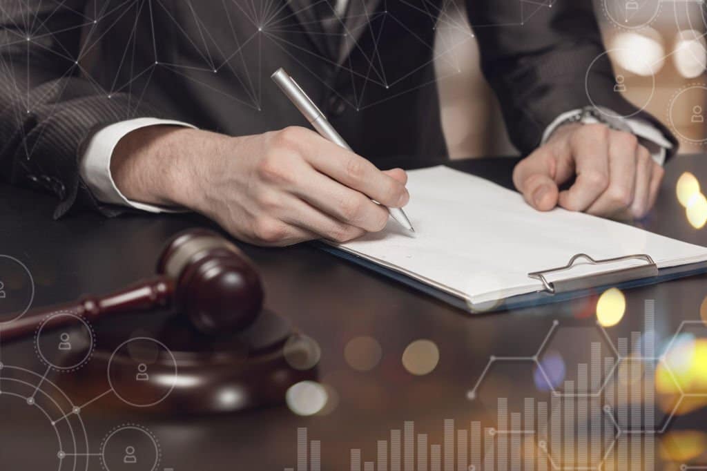 Law Firm Markerting  - a lawyer sitting at a desk with a gavel on it writing on a paper and statistics and marketing icons flow over the image.